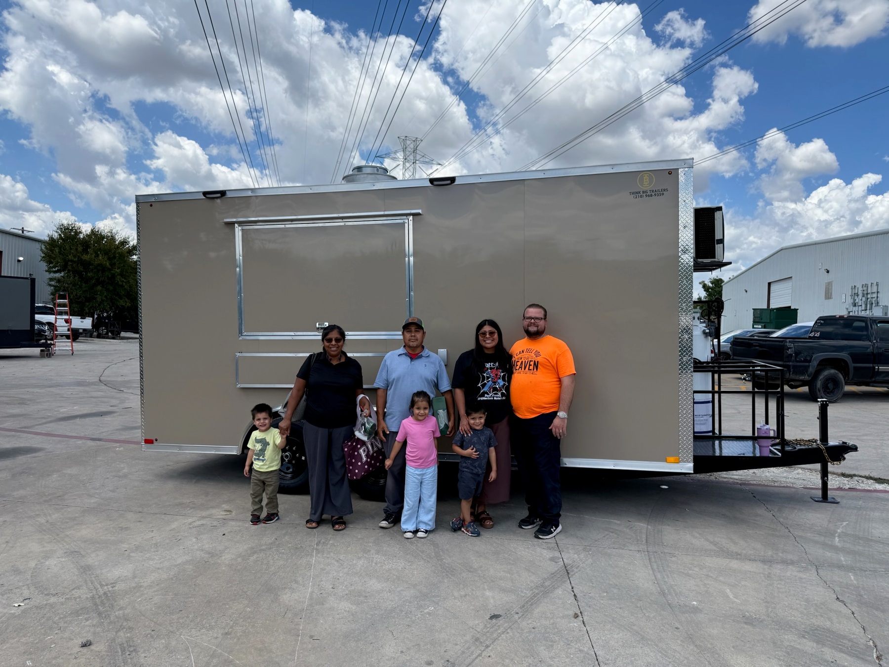 Customers celebrating delivery of their beige custom food trailer, September 22, 2026