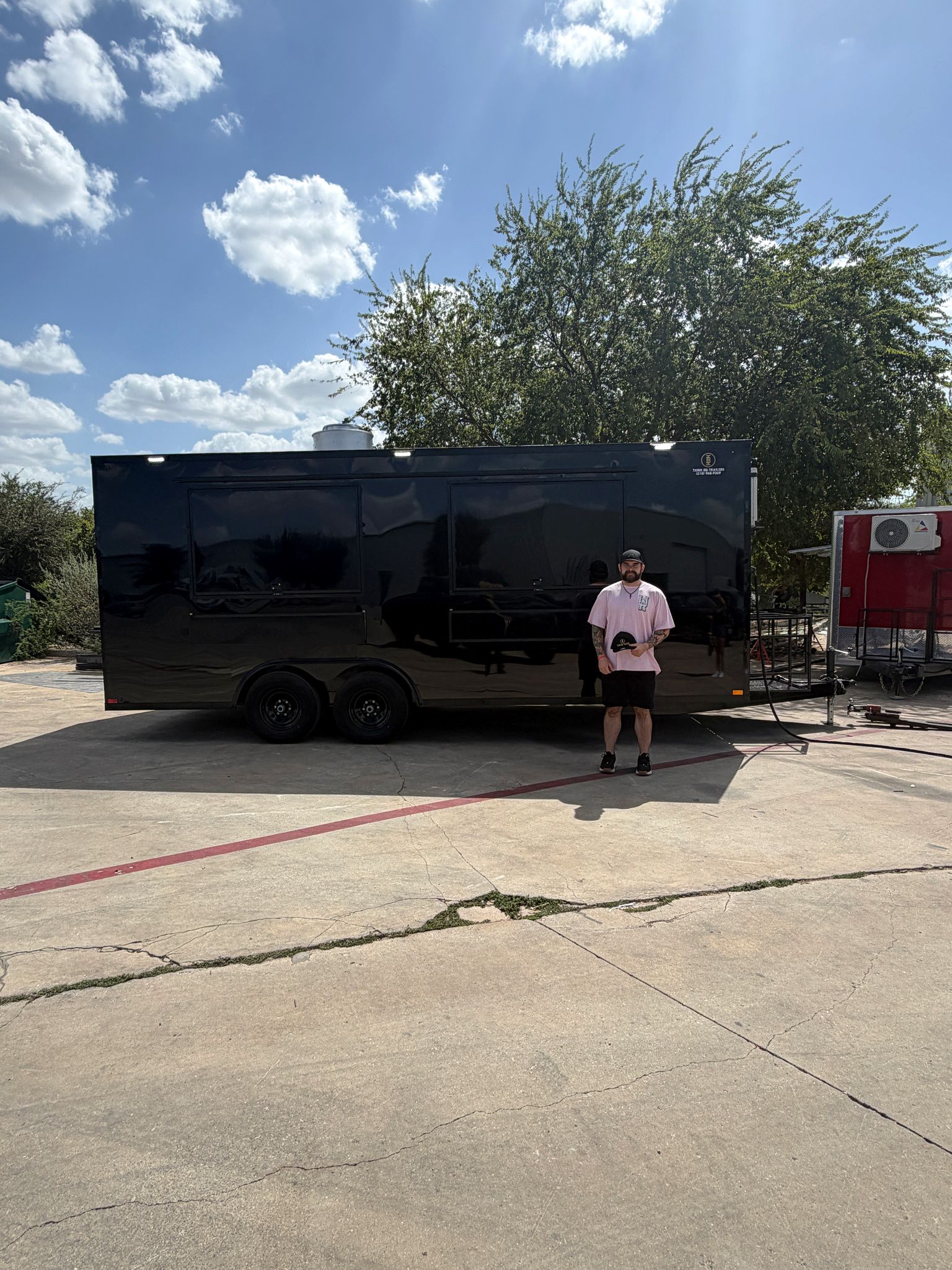 Customer with a black custom food trailer at delivery, September 16, 2026