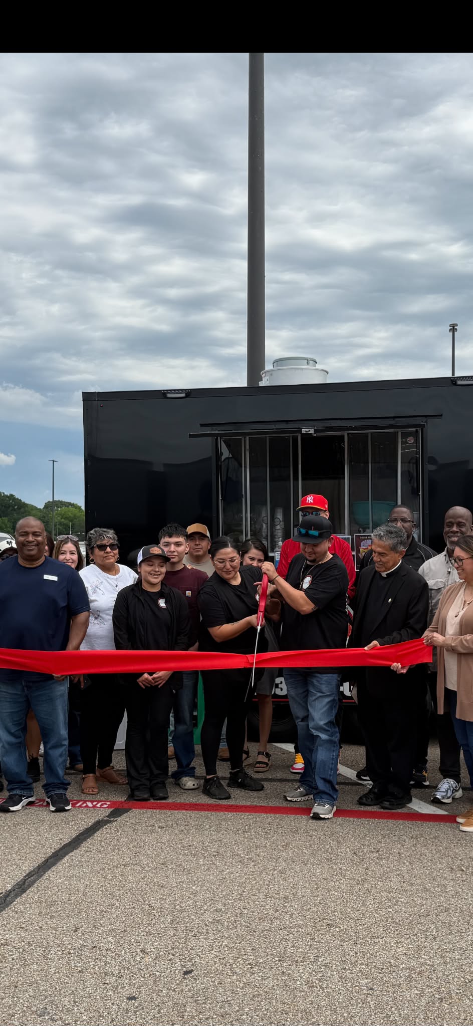 Customers celebrating their food trailer grand opening with a ribbon cutting