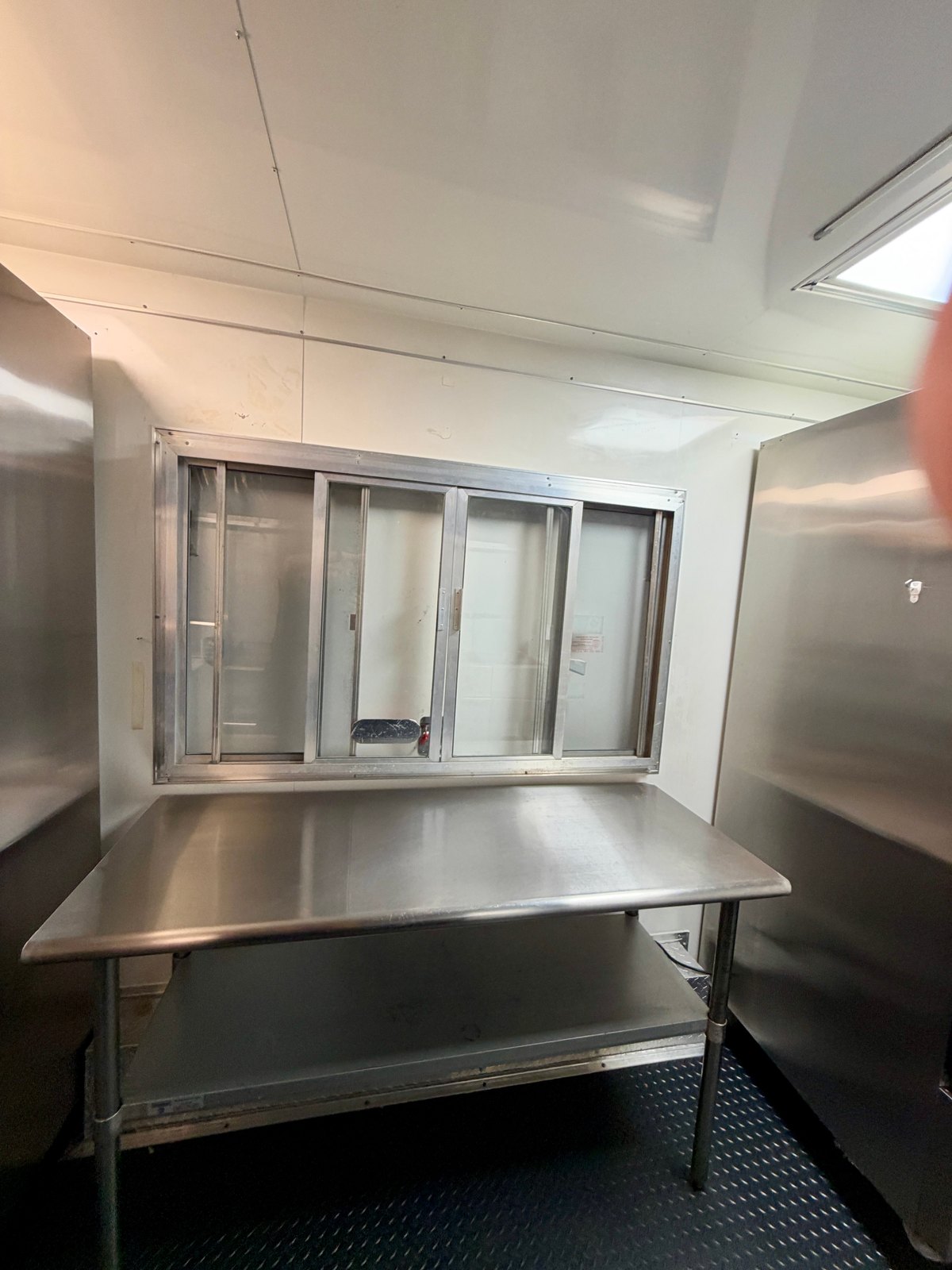 Pre-owned black 8.5 × 16 ft trailer — Interior service window and work table