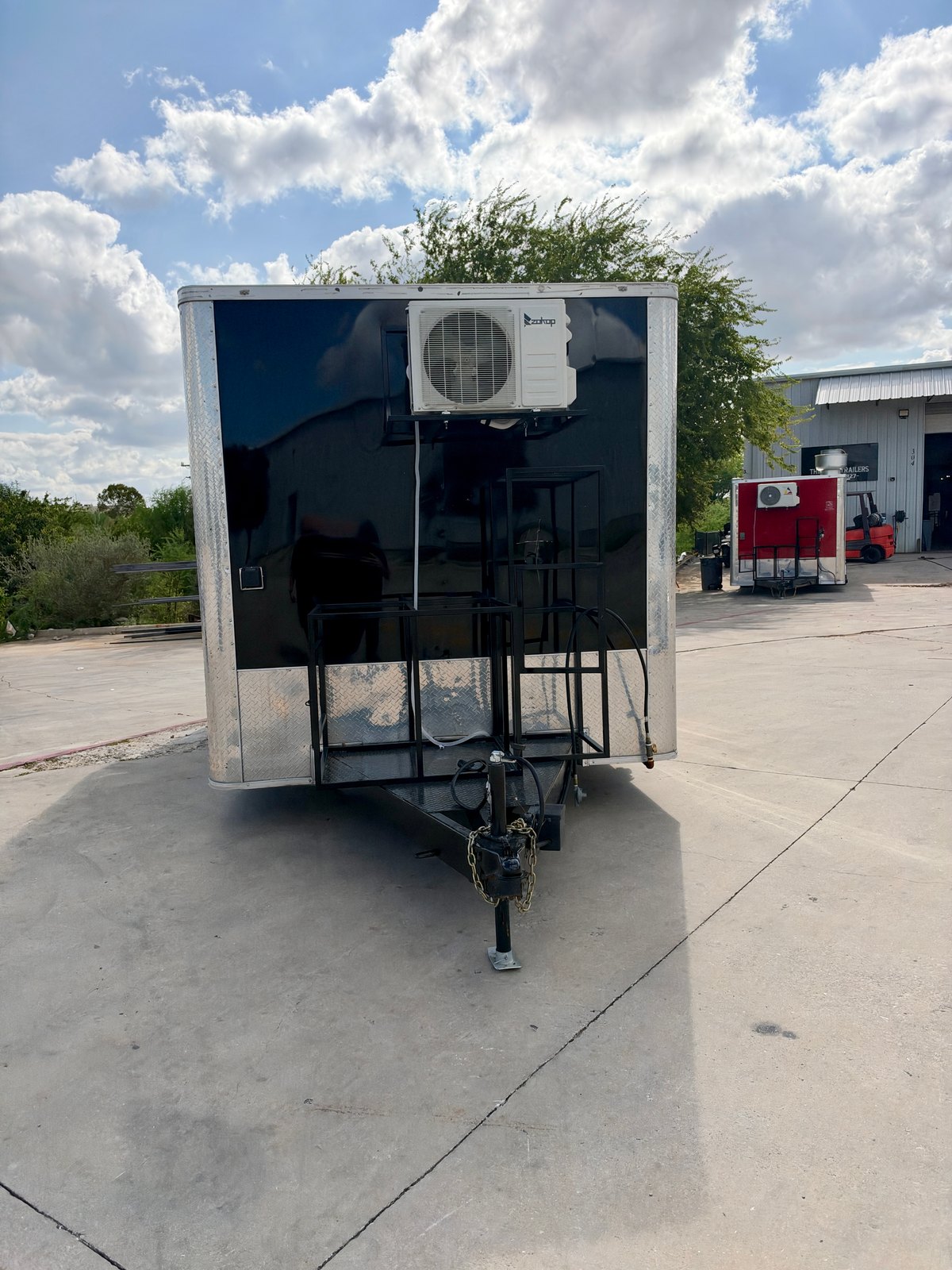 Pre-owned black 8.5 × 16 ft trailer — Front exterior and hitch